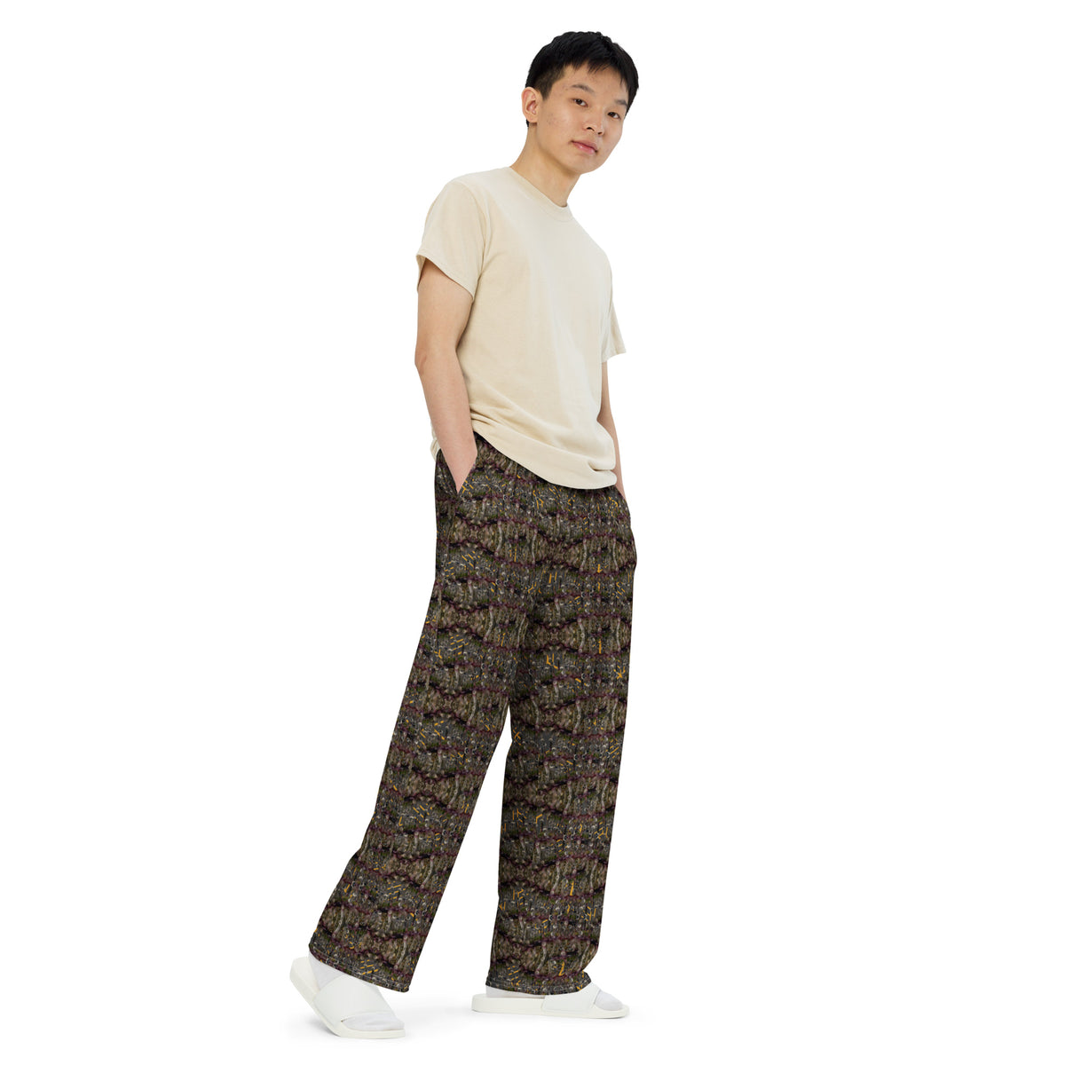 Unisex white wide-leg pants with all-over cannabis print by BudWear, shown from the right front angle.